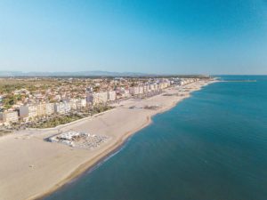 Aerial view of beach and coastal cityscape.