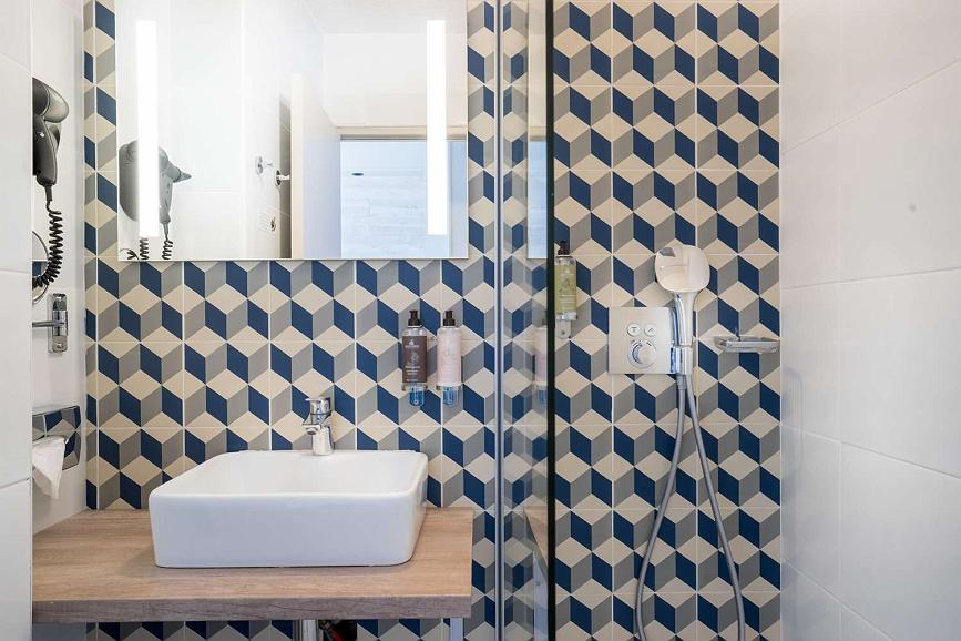 Salle de bain moderne avec carrelage géométrique.