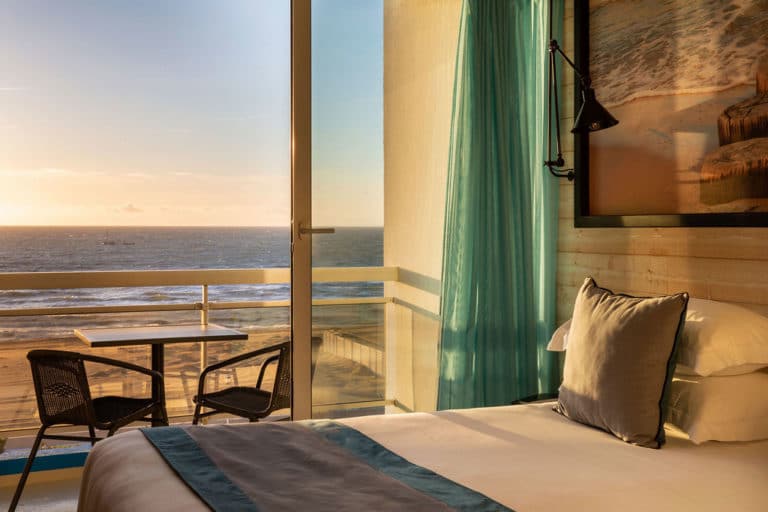 Chambre d'hôtel avec vue sur la mer au coucher.