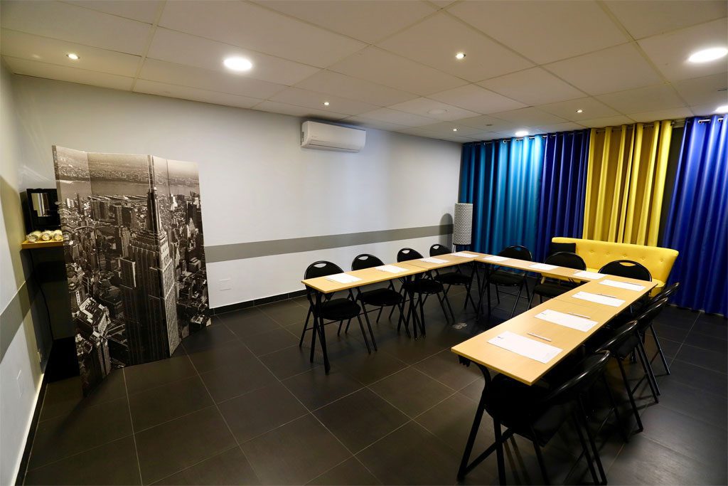 Salle de réunion avec tables et chaises modernes.